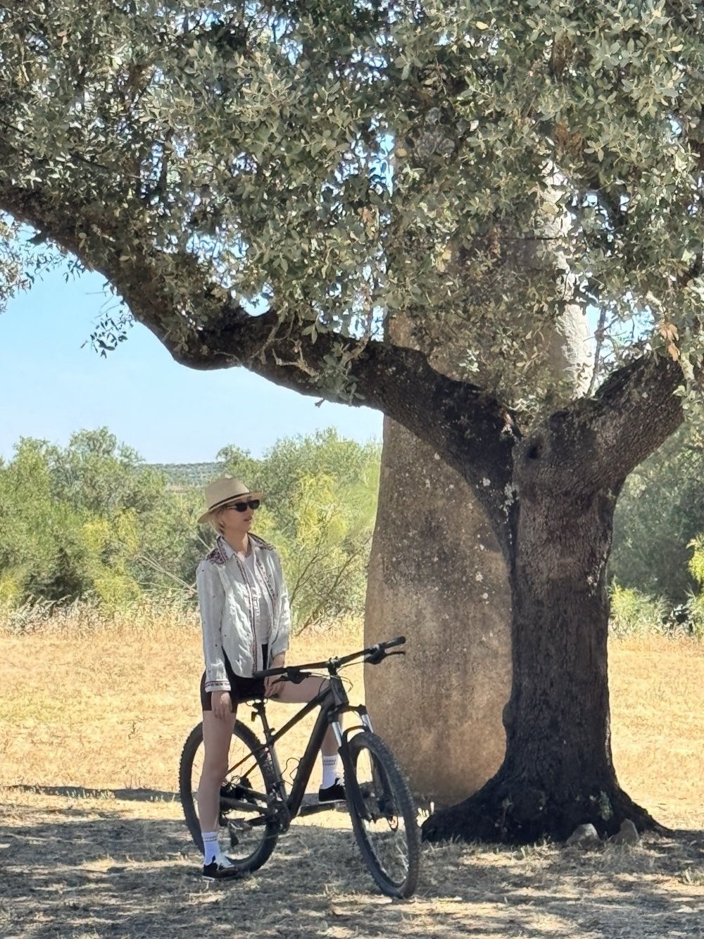 Jamie Zhao standing with a bike under a tree